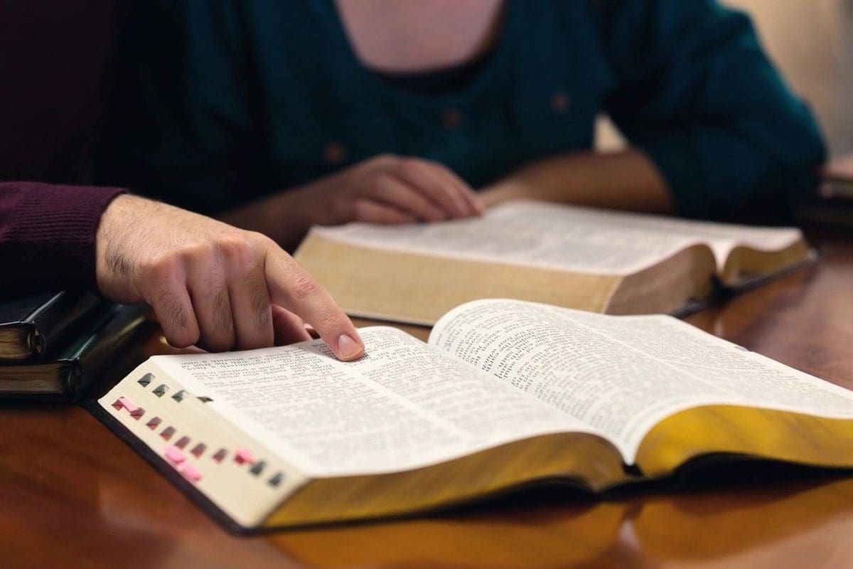 A person is reading the bible on their desk.